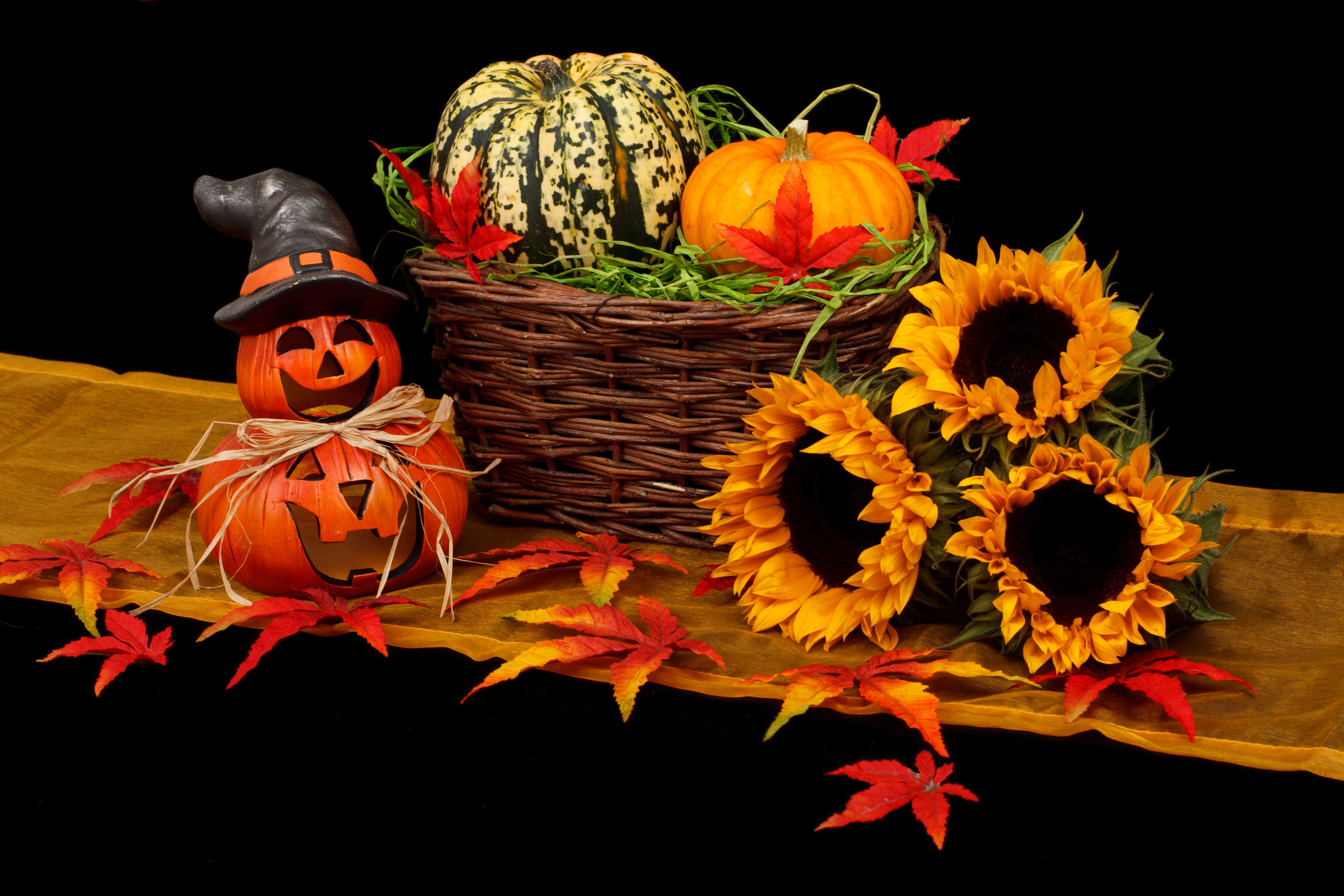 Picture of basket with pumpkins in it next to sunflowers and jakolantern for post of fall decorating on a budget