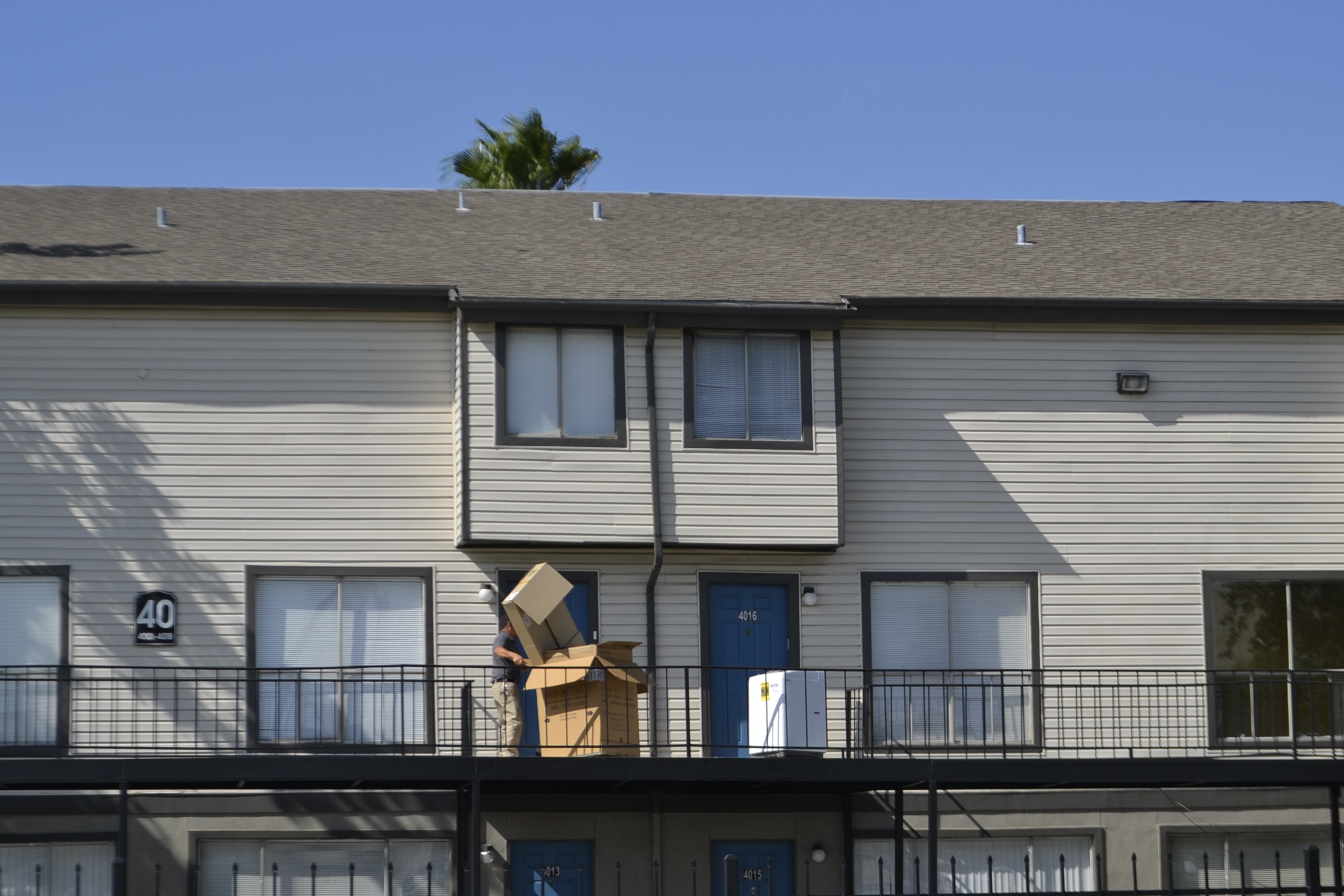 man moving boxes in front of a home