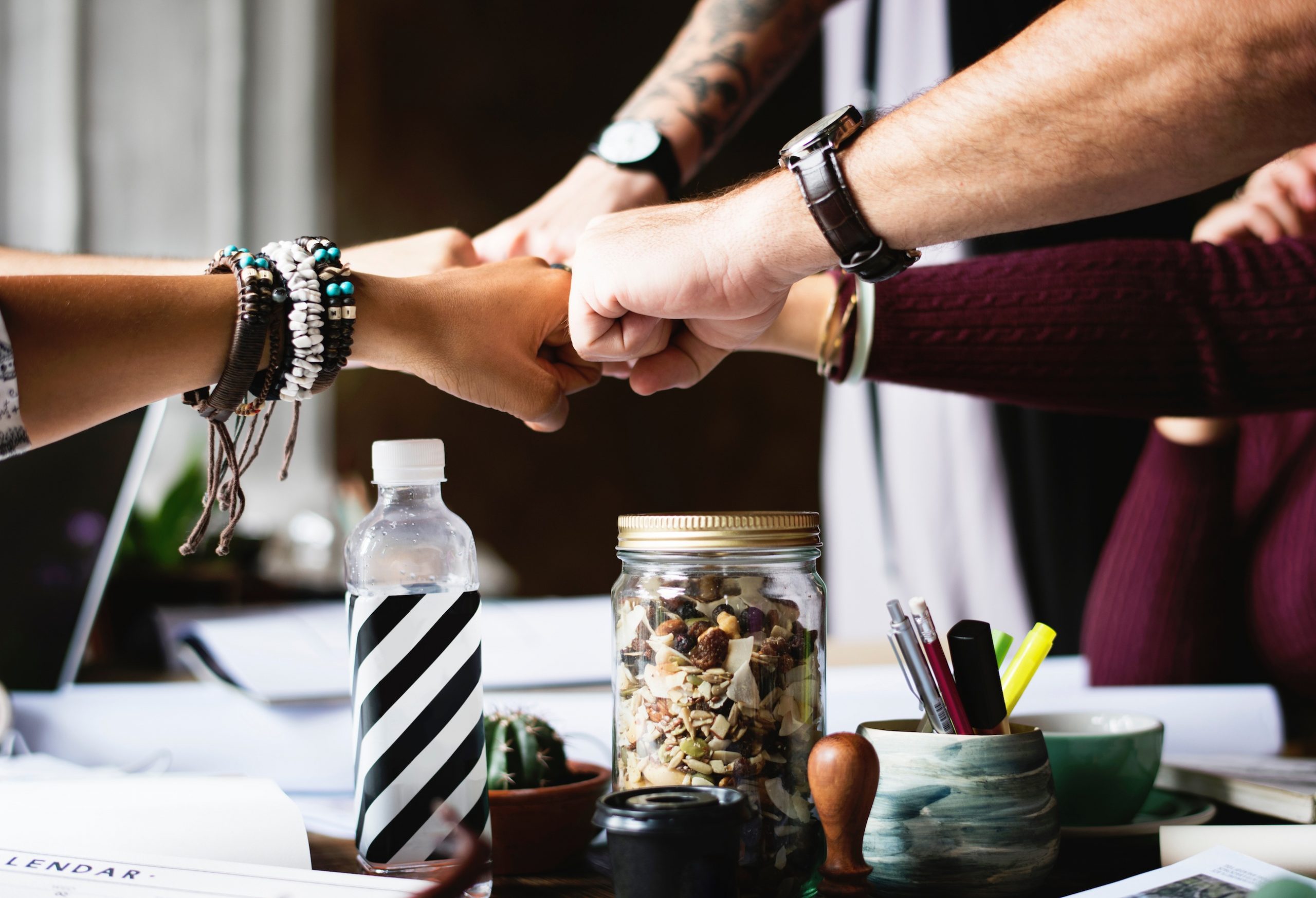 group of people meeting their fists together over a table