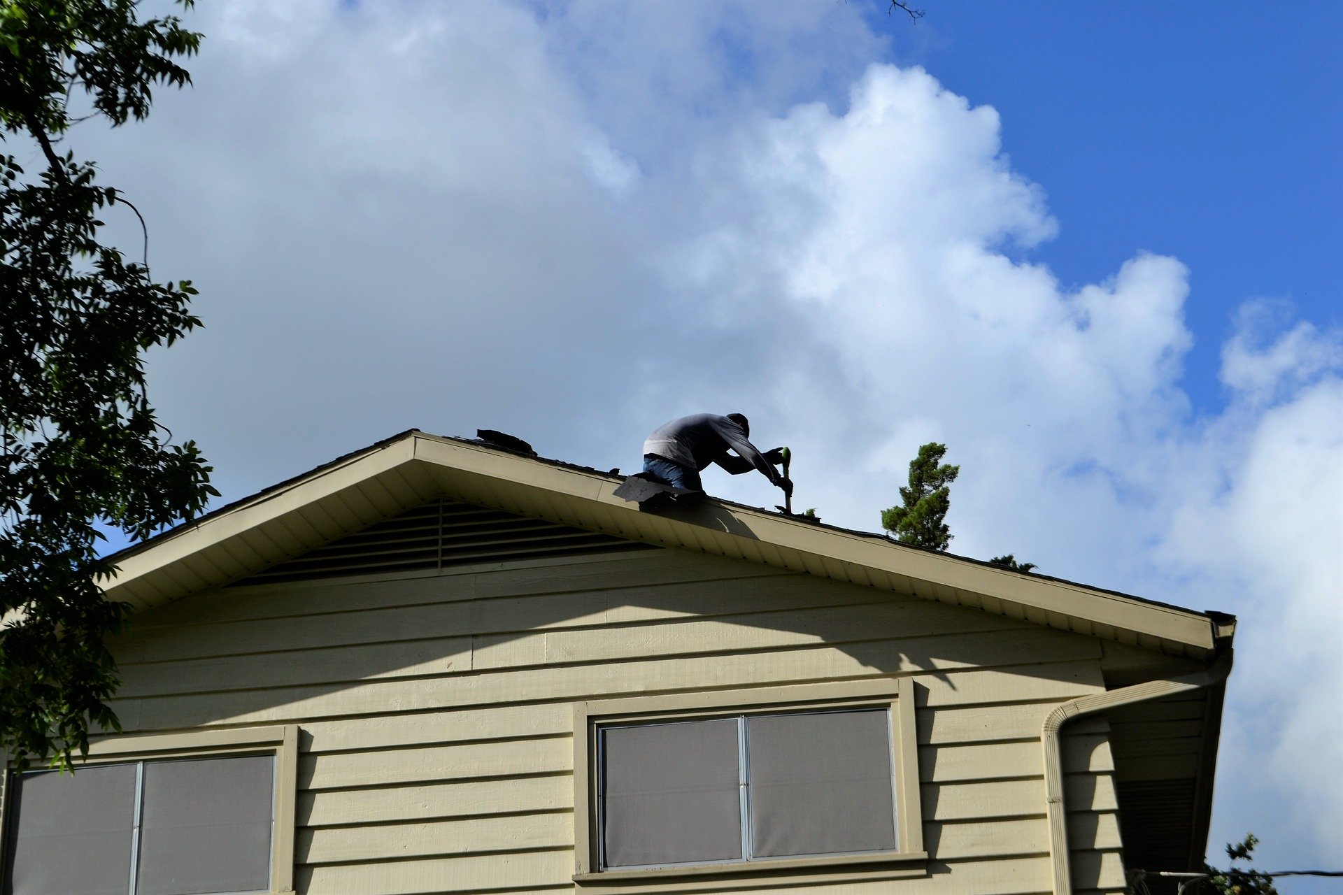 two roofers working on a roof of a home